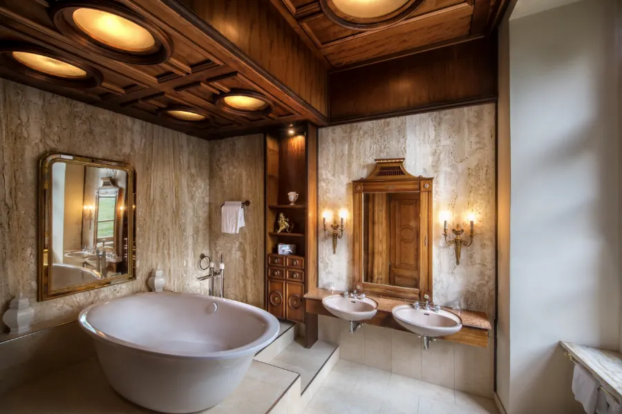 Badezimmer einer Suite mit freistehender Badewanne, Holzkassettendecke und zwei Waschbecken